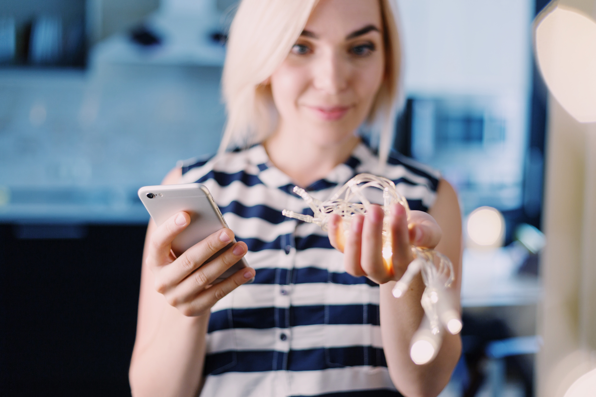 Woman holding phone and earbuds