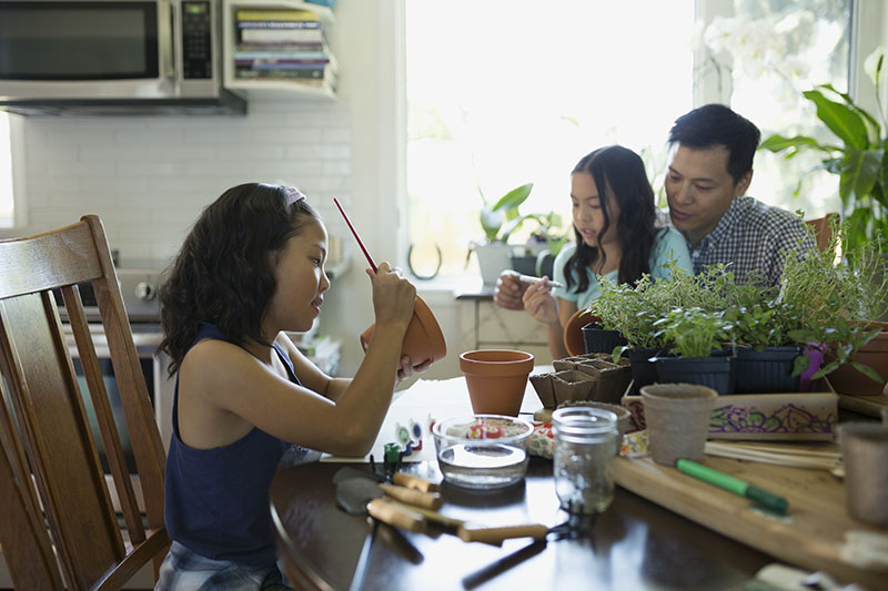 family painting clay garden pots together