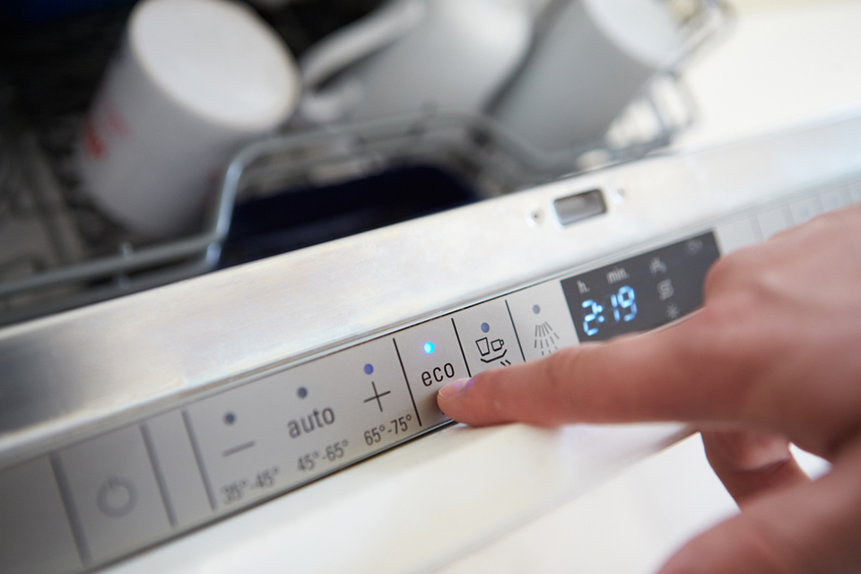 man setting eco mode on an appliance