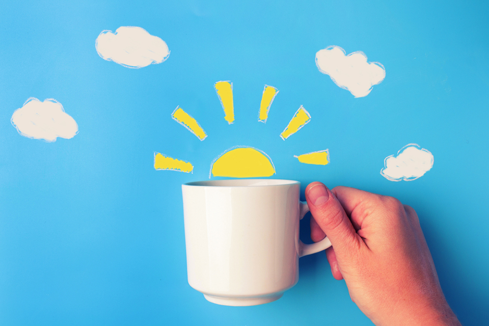 graphic of coffee cup with sunrise peaking from the cup