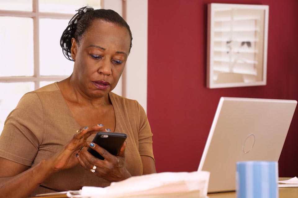 woman at laptop on phone