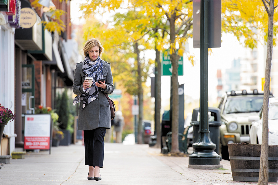 woman walking down the sidewalk on her cell phone